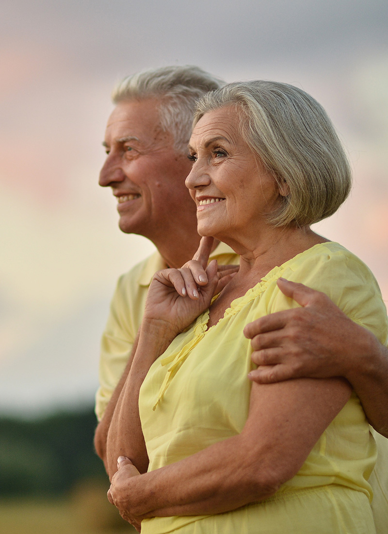 an elderly couple looking at the sunset outside of a skilled nursing facility 
